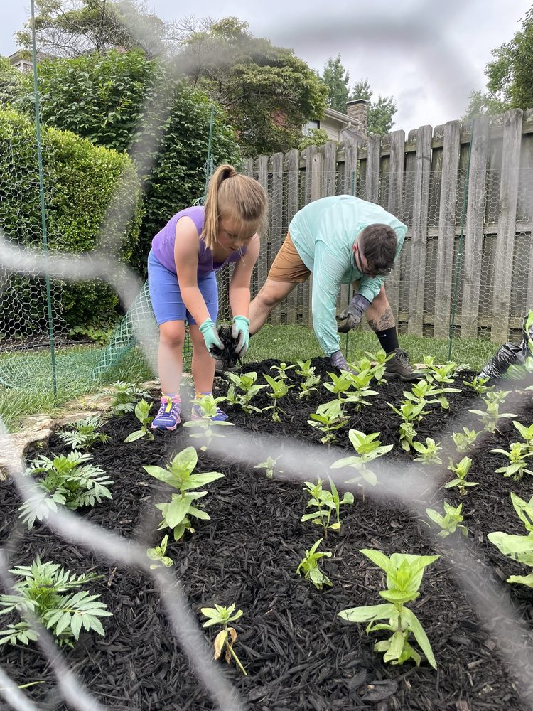Josie and her dad planting in the garden